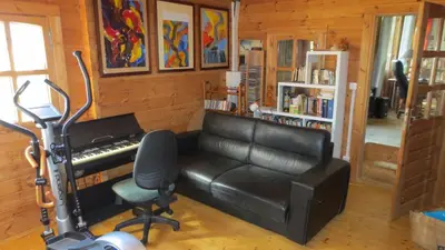 a living room with a piano and a chair at chalet 4 à 6 pers à la campagne 15 mn plages et Ajaccio grand terrain arboré calme assuré in Afa
