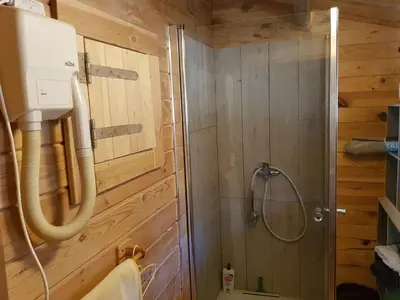 a bathroom with a shower in a wooden cabin at chalet 4 à 6 pers à la campagne 15 mn plages et Ajaccio grand terrain arboré calme assuré in Afa
