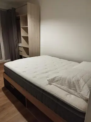 a bed in a room with a white mattress at Appartement traversant 2 chambres in Ajaccio