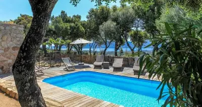 a pool in a yard with chairs and a tree at Villa Tavara Di Porto-Vecchio in Porto-Vecchio