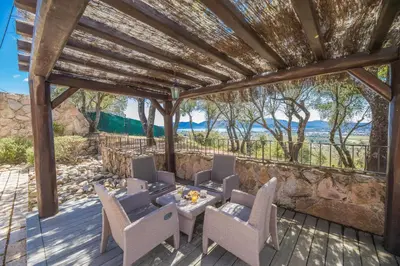 a pergola with a table and chairs on a deck at Villa Tavara Di Porto-Vecchio in Porto-Vecchio