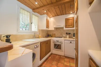 a kitchen with white appliances and wooden cabinets at Villa Tavara Di Porto-Vecchio in Porto-Vecchio