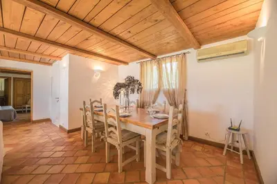 a dining room with a wooden table and chairs at Villa Tavara Di Porto-Vecchio in Porto-Vecchio