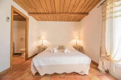 a bedroom with a white bed with two pillows at Villa Tavara Di Porto-Vecchio in Porto-Vecchio