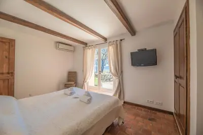 a bedroom with a bed and a tv on the wall at Villa Funtanedda Di Porto-Vecchio in Porto-Vecchio