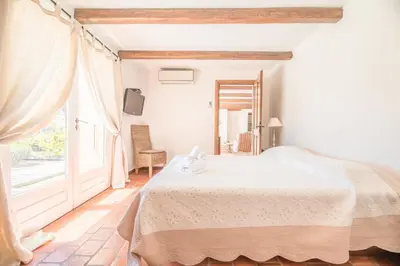 a bedroom with a bed and a large window at Villa Funtanedda Di Porto-Vecchio in Porto-Vecchio