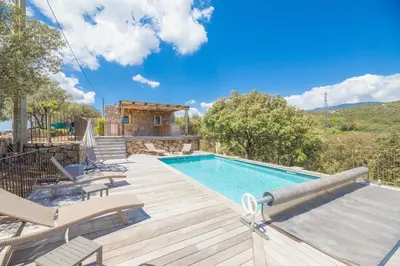 a swimming pool with a deck and a house at Villa Funtanedda Di Porto-Vecchio in Porto-Vecchio