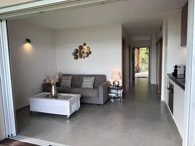 a living room with a couch and a table at Les oliviers 6 - Appartement pieds dans l'eau in Porto-Vecchio