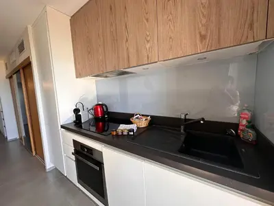 a kitchen with a black counter top and a sink at Les oliviers 6 - Appartement pieds dans l'eau in Porto-Vecchio
