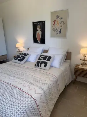 a bedroom with a bed with two pillows on it at Résidence Patios di Pruno in Figari