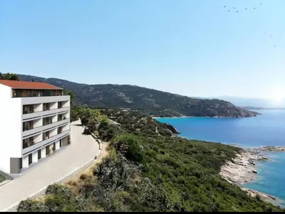 a building on a hill next to the ocean at T4 standing a Cargese in Cargèse