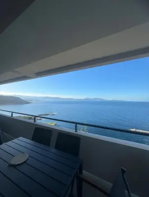 a balcony with a table and a view of the ocean at T4 standing a Cargese in Cargèse