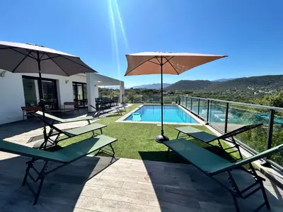 a group of chairs and umbrellas next to a swimming pool at Casacilagna in Zonza
