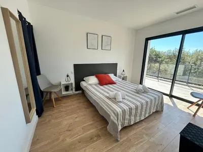 a bedroom with a bed and a large window at Casacilagna in Zonza
