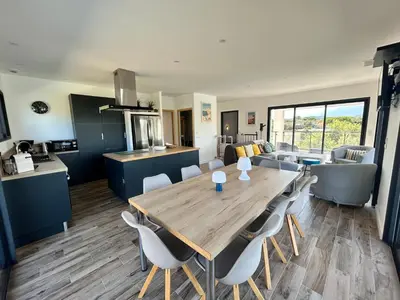 a kitchen and dining room with a wooden table and chairs at Casacilagna in Zonza
