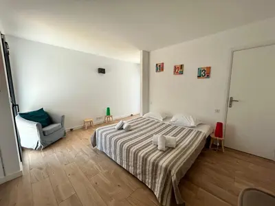 a bedroom with a large bed and a chair at Casacilagna in Zonza