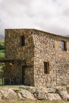 an old stone building with windows on a hill at Domaine Acciola in Feliceto