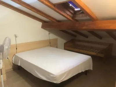 a white bed in a room with wooden ceilings at Bravone in Linguizzetta