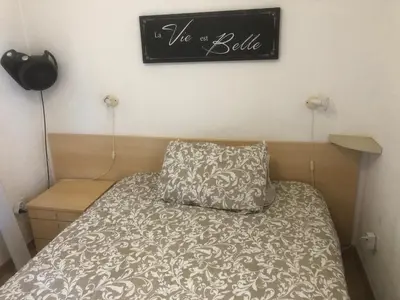 a bed with a pillow and a sign on the wall at Bravone in Linguizzetta