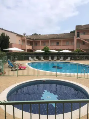 a large swimming pool with chairs and a building at Bravone in Linguizzetta