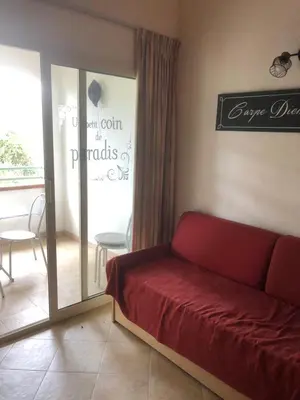 a living room with a red couch and a balcony at Bravone in Linguizzetta