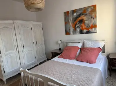 a bedroom with a bed with two red pillows at A SUARELLA - Villa climatisée - 4 chambres - piscine chauffée in Sainte-Lucie de Porto-Vecchio