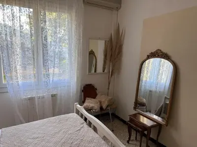 a bedroom with a bed and a mirror and a chair at A SUARELLA - Villa climatisée - 4 chambres - piscine chauffée in Sainte-Lucie de Porto-Vecchio