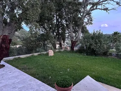 a garden with trees and a grave in the grass at A SUARELLA - Villa climatisée - 4 chambres - piscine chauffée in Sainte-Lucie de Porto-Vecchio