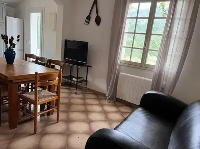 a living room with a table and a couch and a dining room at A SUARELLA - Villa climatisée - 4 chambres - piscine chauffée in Sainte-Lucie de Porto-Vecchio