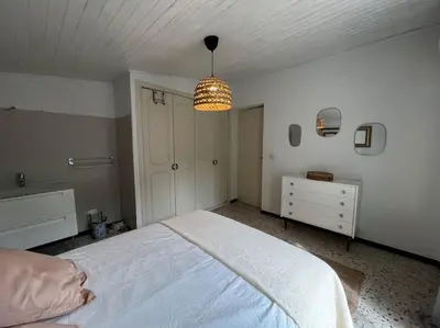 a bedroom with a white bed and a chandelier at A SUARELLA - Villa climatisée - 4 chambres - piscine chauffée in Sainte-Lucie de Porto-Vecchio