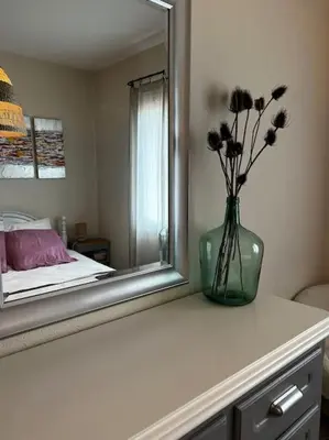 a vase with flowers on a counter in front of a mirror at A SUARELLA - Villa climatisée - 4 chambres - piscine chauffée in Sainte-Lucie de Porto-Vecchio