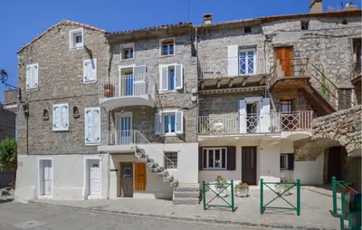 an old stone building with white windows and stairs at Cozy Home In Sollacaro With Wifi in Sollacaro
