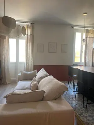 a bed with pillows on it in a living room at Superbe appartement 2 chambres plein centre in Ajaccio