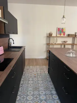 a kitchen with black cabinets and a tile floor at Superbe appartement 2 chambres plein centre in Ajaccio