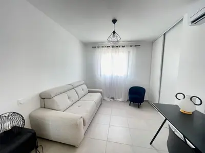 a living room with a couch and a table at Villa Pietrosella, vue sur la baie d'Ajaccio in Agnarelu