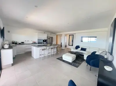 a kitchen and living room with a couch and a table at Villa Pietrosella, vue sur la baie d'Ajaccio in Agnarelu
