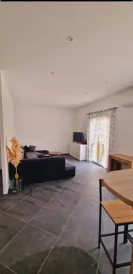 a living room with a couch and a table at Maison Vacance Proche De Calvi in Calenzana