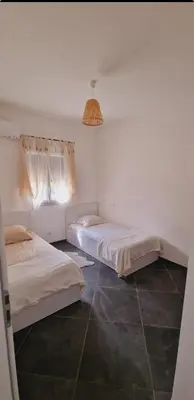 a bedroom with two beds and a pendant light at Maison Vacance Proche De Calvi in Calenzana