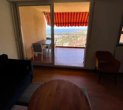 a living room with a table and a large sliding glass door at VUE EXCEPTIONNELLE - Ajaccio T3 rte Sanguinaires - Santa Lina in Ajaccio