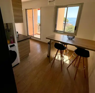 a kitchen with a table and two bar stools at VUE EXCEPTIONNELLE - Ajaccio T3 rte Sanguinaires - Santa Lina in Ajaccio