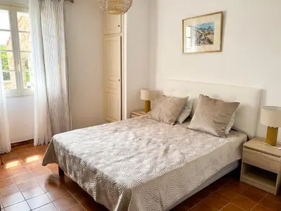 a bedroom with a bed and two lamps and a window at Villa NAOMI piscine à 100 m de la plage in Olmeto