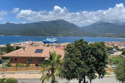 a house with a view of the water and a boat at Studio équipé vue mer in Propriano