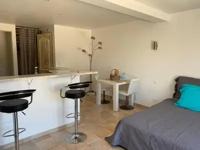 a bedroom with a bed and a bar with stools at Studio équipé vue mer in Propriano