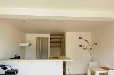 a white room with a counter and a table at Studio équipé vue mer in Propriano