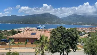 a house with a boat in the water at Studio équipé vue mer in Propriano
