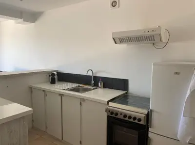 a small kitchen with a sink and a refrigerator at Studio équipé vue mer in Propriano