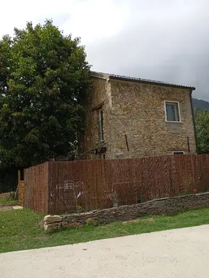 a brick house behind a wooden fence at A casettuccia santu petru in Santo-Pietro-di-Venaco