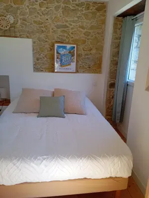 a bed in a room with a stone wall at A casettuccia santu petru in Santo-Pietro-di-Venaco