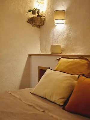 a bedroom with a bed with a light on the wall at Ajaccio Hypercentre, Superbe appartement dans une ancienne écurie du XVIIIe Siècle in Ajaccio