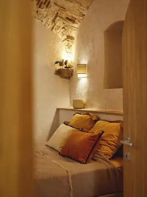 a bed with two pillows in a small room at Ajaccio Hypercentre, Superbe appartement dans une ancienne écurie du XVIIIe Siècle in Ajaccio